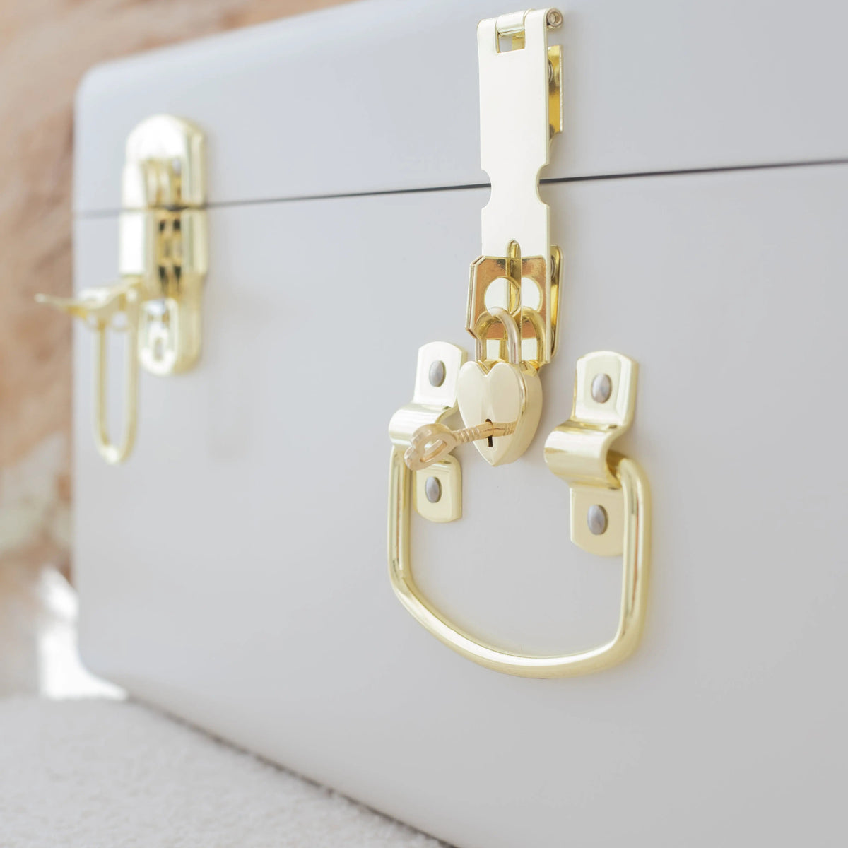 White jewelry box with gold accents on a neutral background
