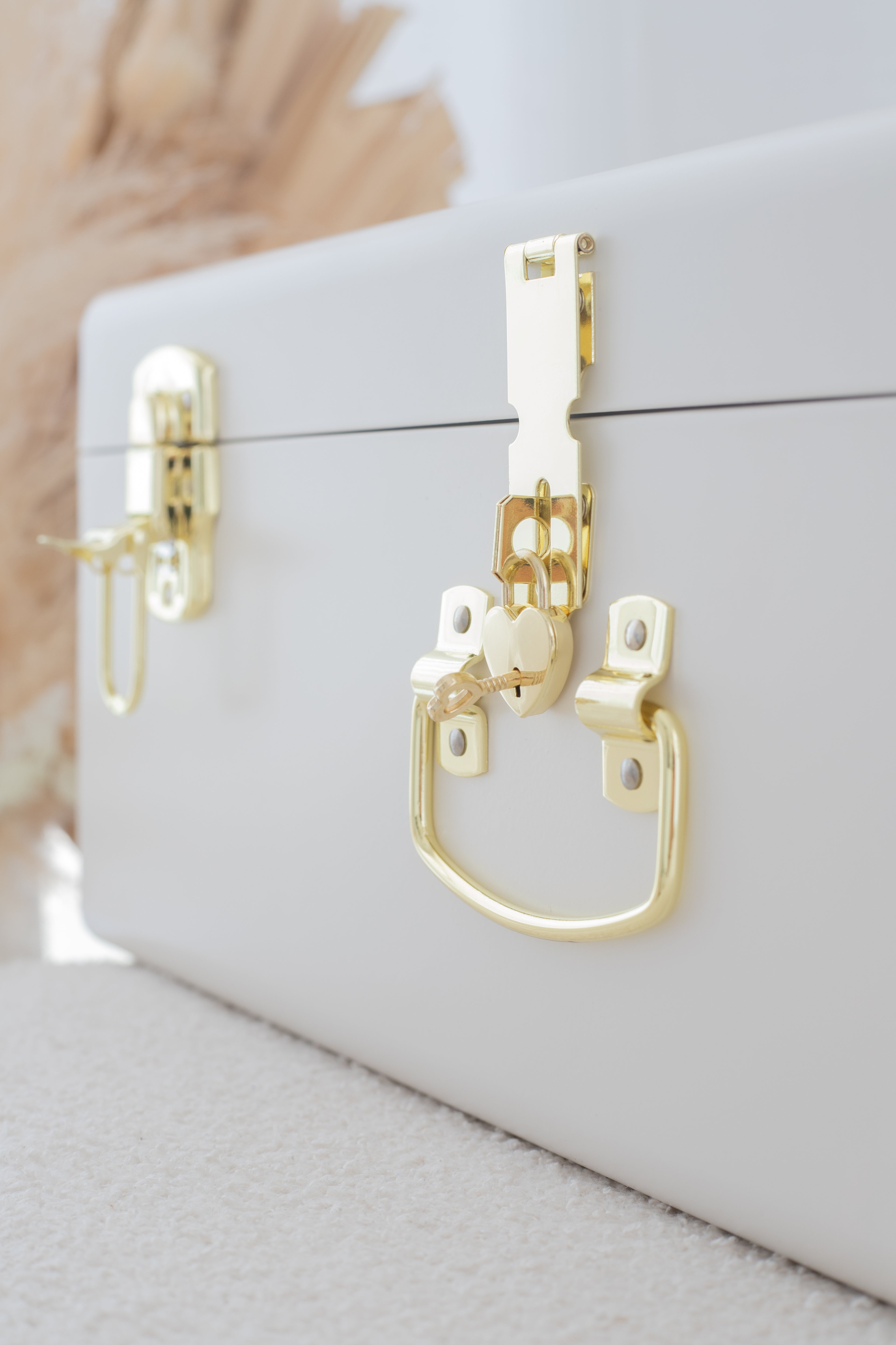 White jewelry box with gold accents on a neutral background