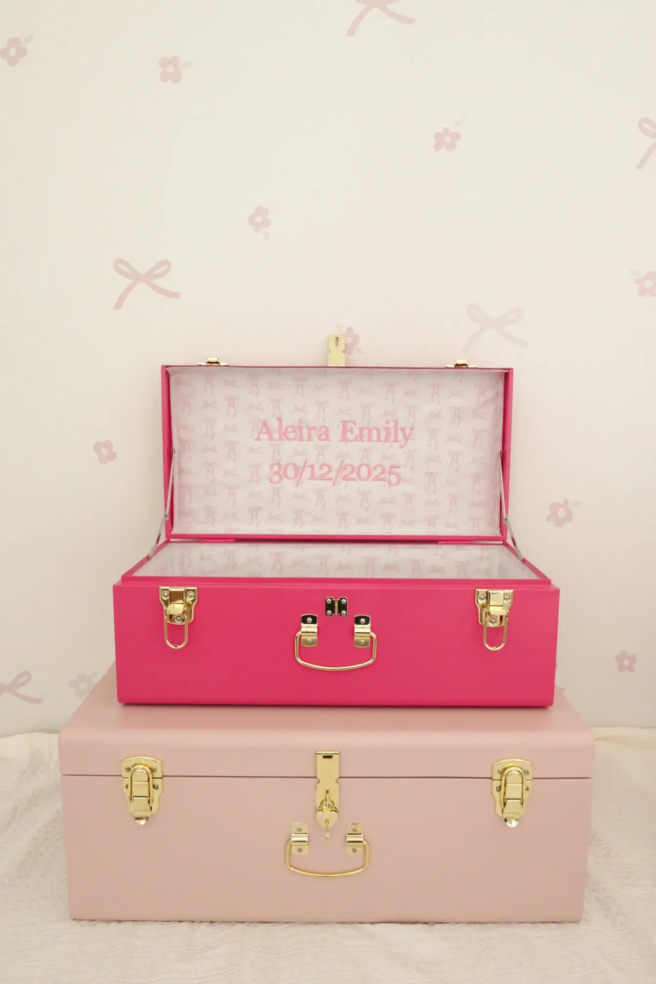 Pink and beige storage boxes with gold accents on a light pink background