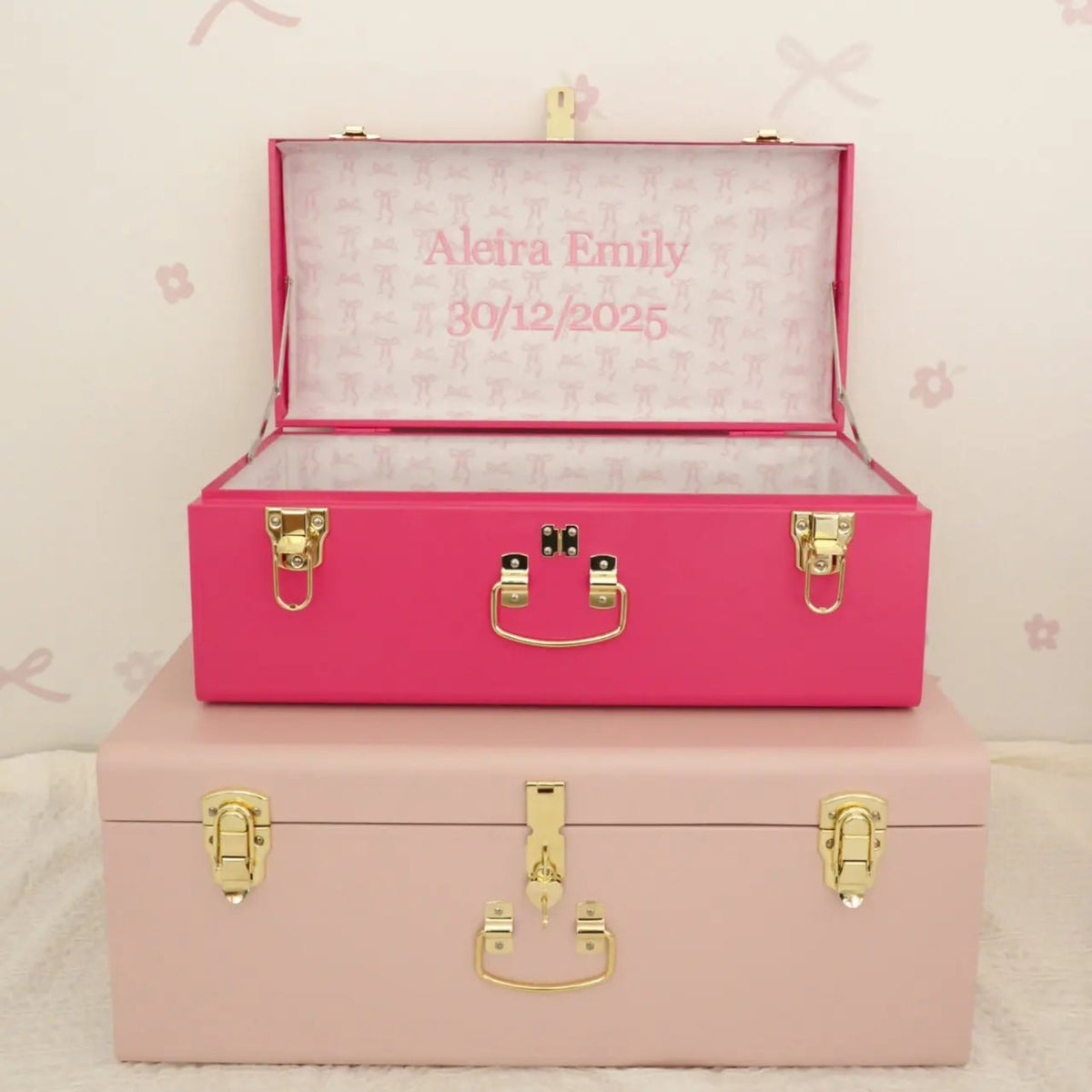 Pink and beige storage boxes with gold accents on a light pink background