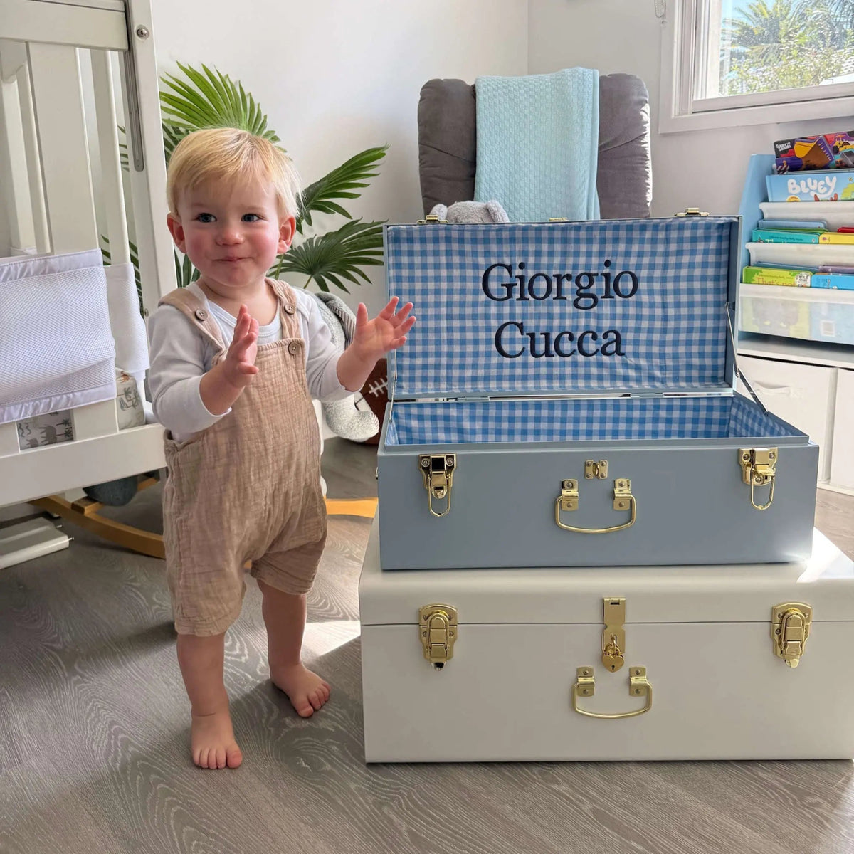 Child standing next to a set of storage boxes with &