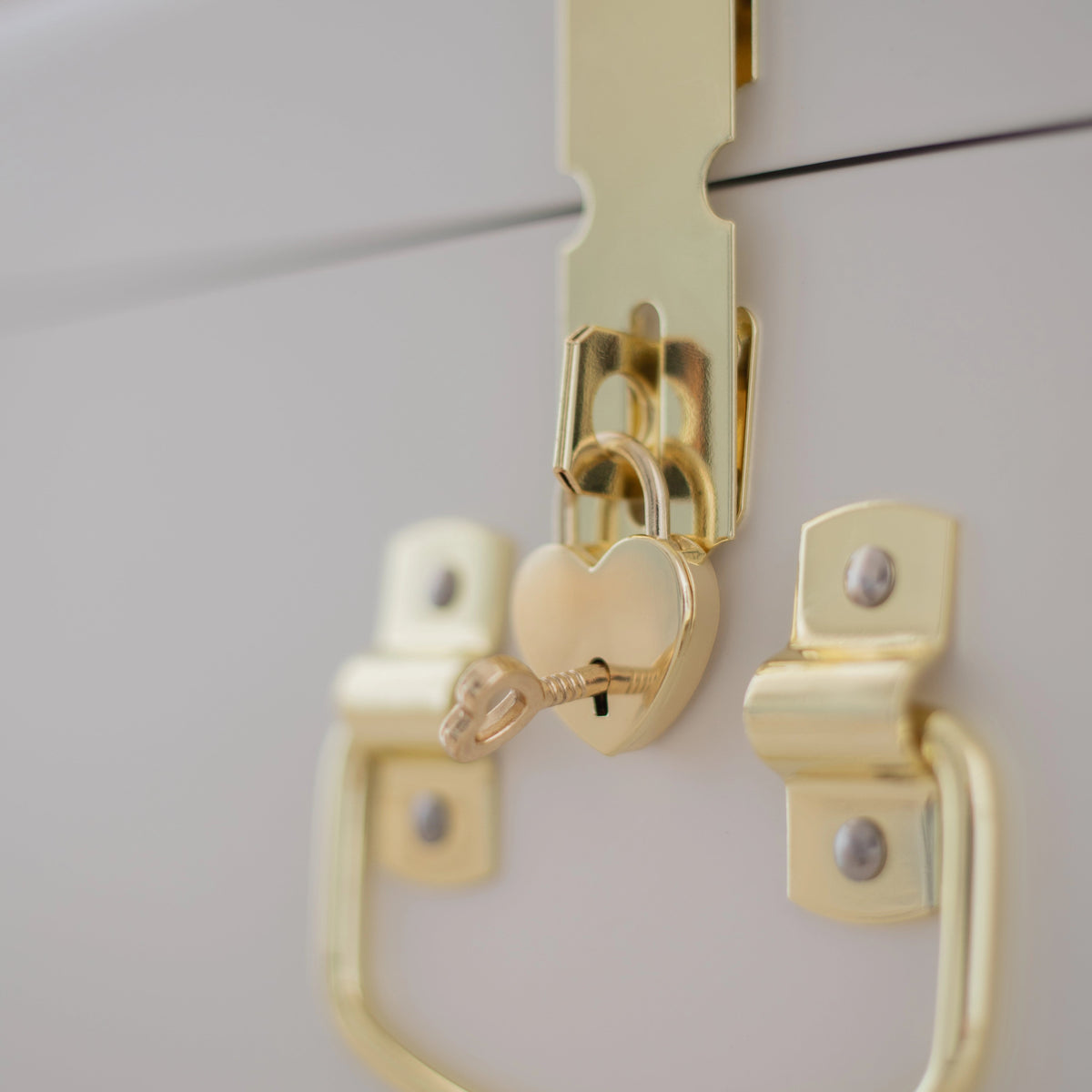 Gold cabinet handle and lock on a white cabinet