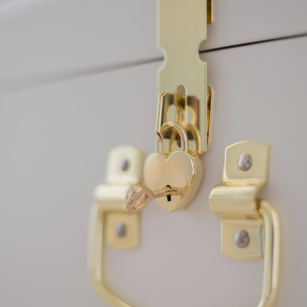 Gold cabinet handle and lock on a white cabinet