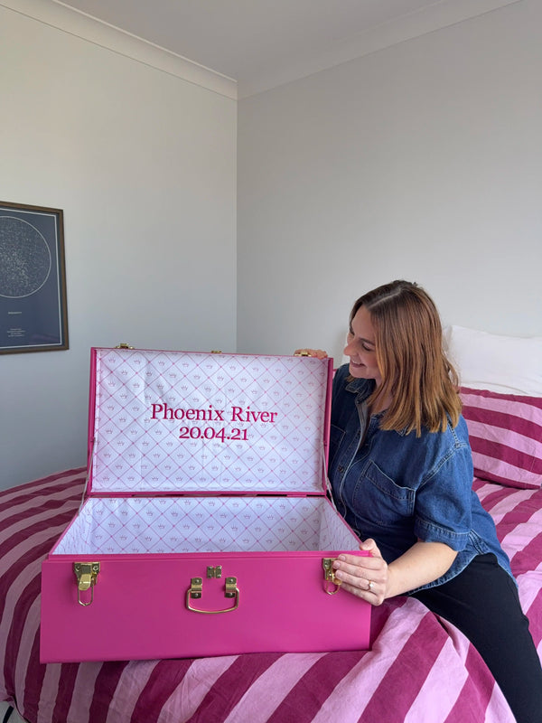 Woman holding a pink and white box with 'Phoenix River' and a date printed on it.