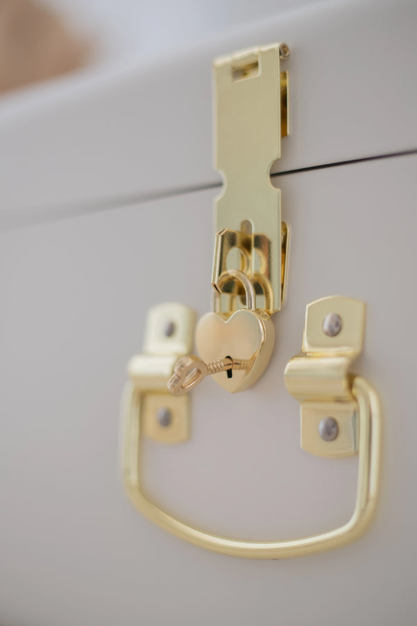 Gold cabinet handle and lock on a white cabinet